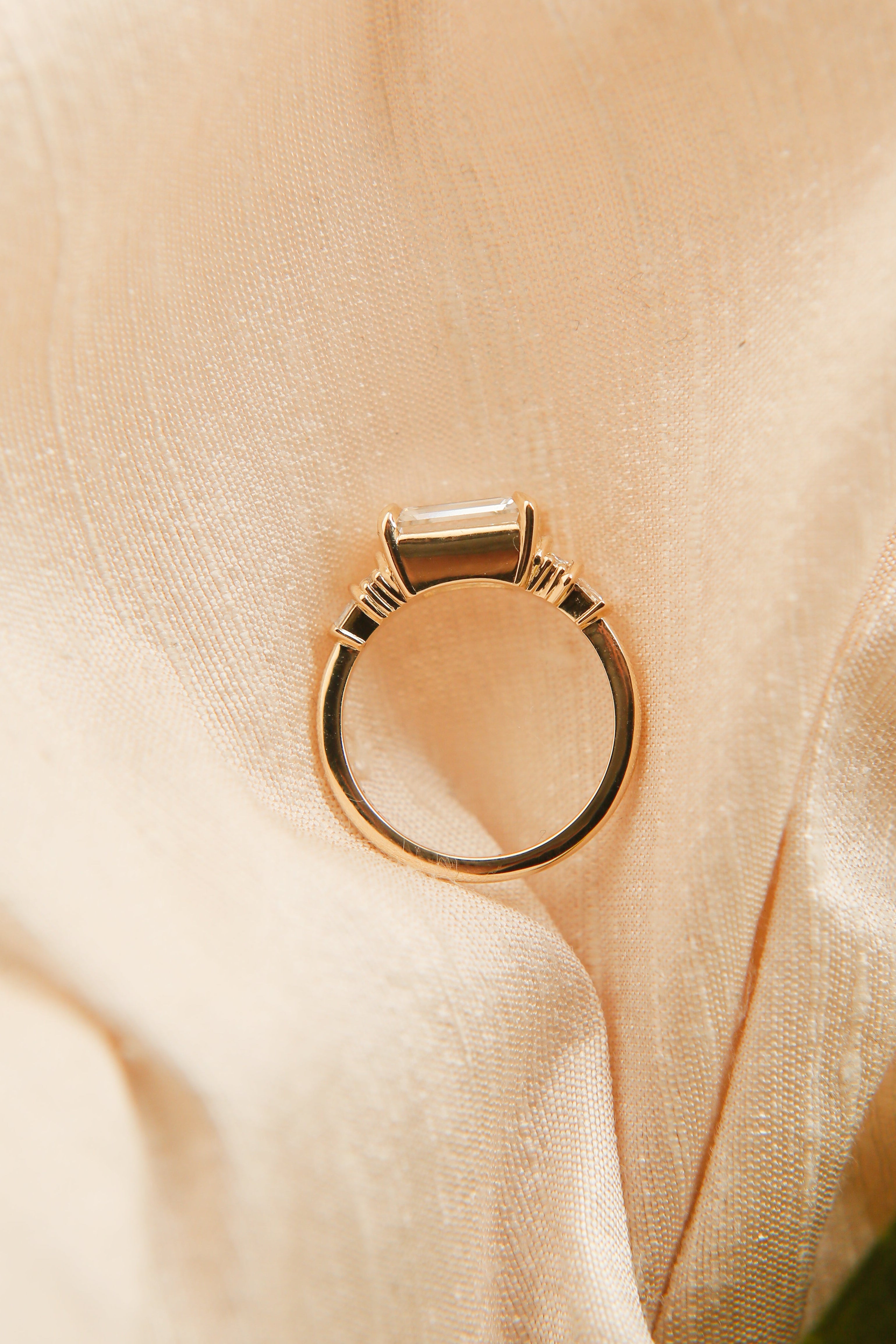 Gold ring on a soft beige fabric background