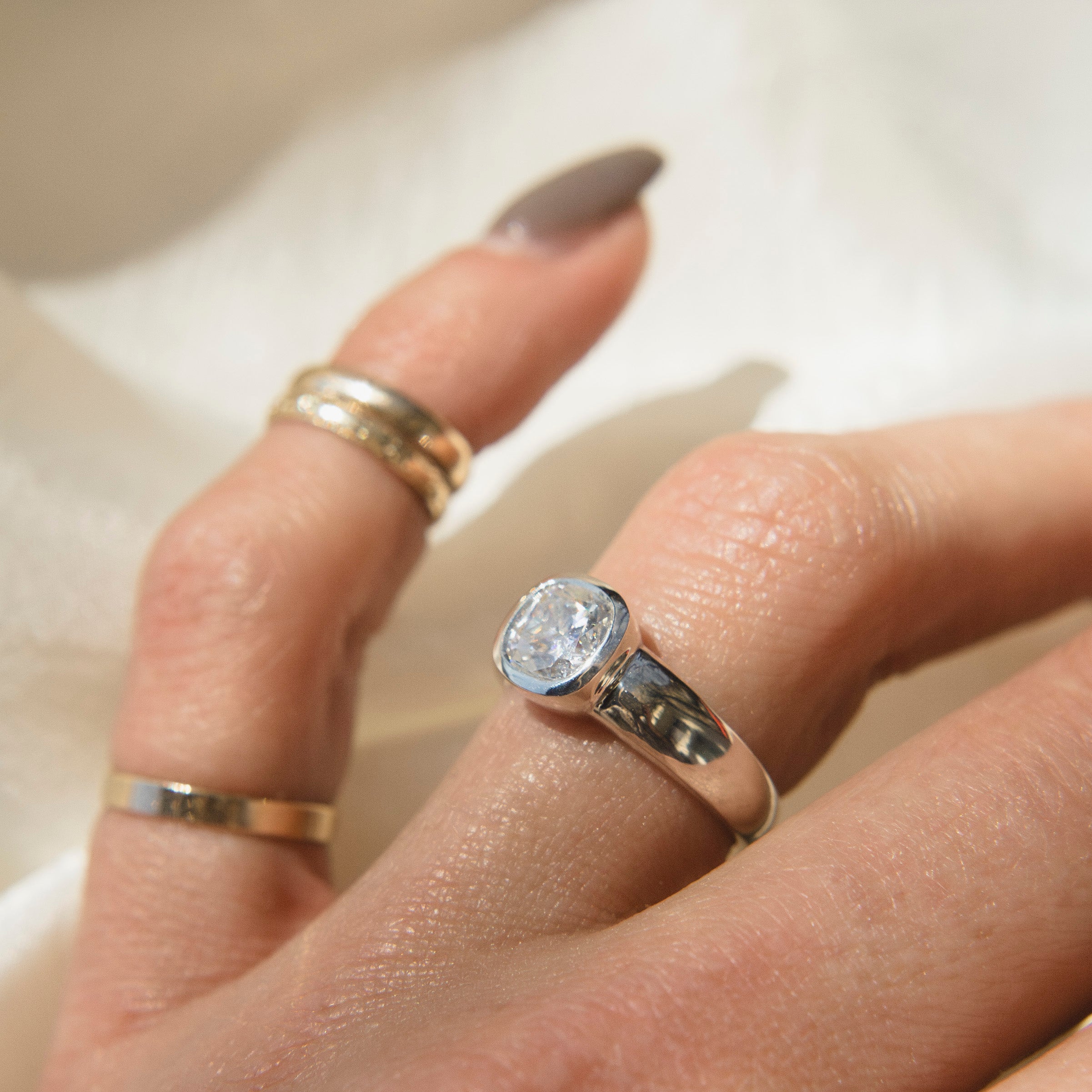 gold ring with a bezel set diamond. This solitaire engagement ring can be made with your desired stone type (Diamond, moissanite, sapphire etc.) and stone shape (Square, Marquis, round, emerald, assher, etc.) and in your choice of metal! (10k yellow or white gold, 14k yellow or white gold, 18k yellow or white gold, platinum and continuum silver.)