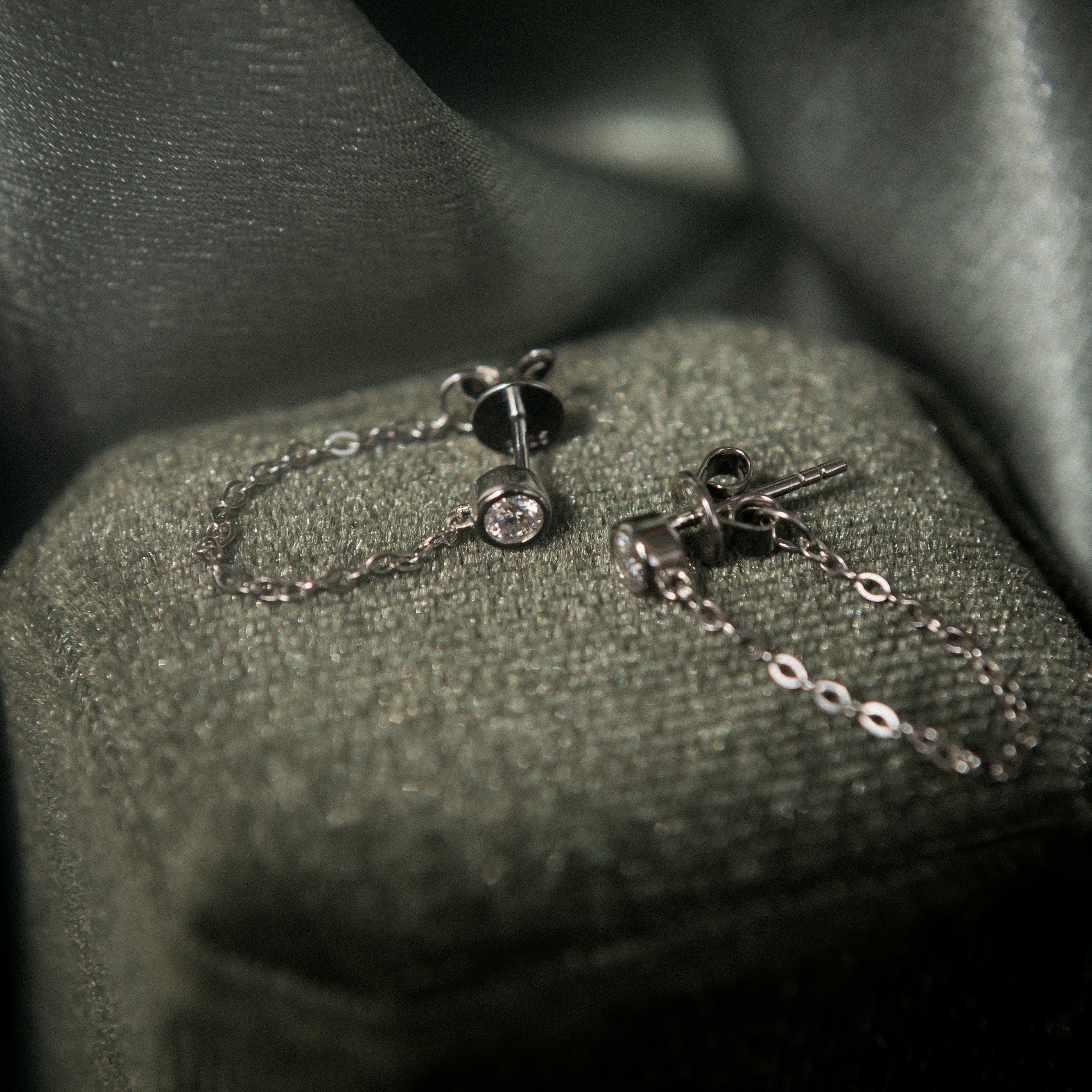White gold filled moissanite studs with a chain that connects from front to back. Sold by cival in bayview Milwaukee wisconsin
