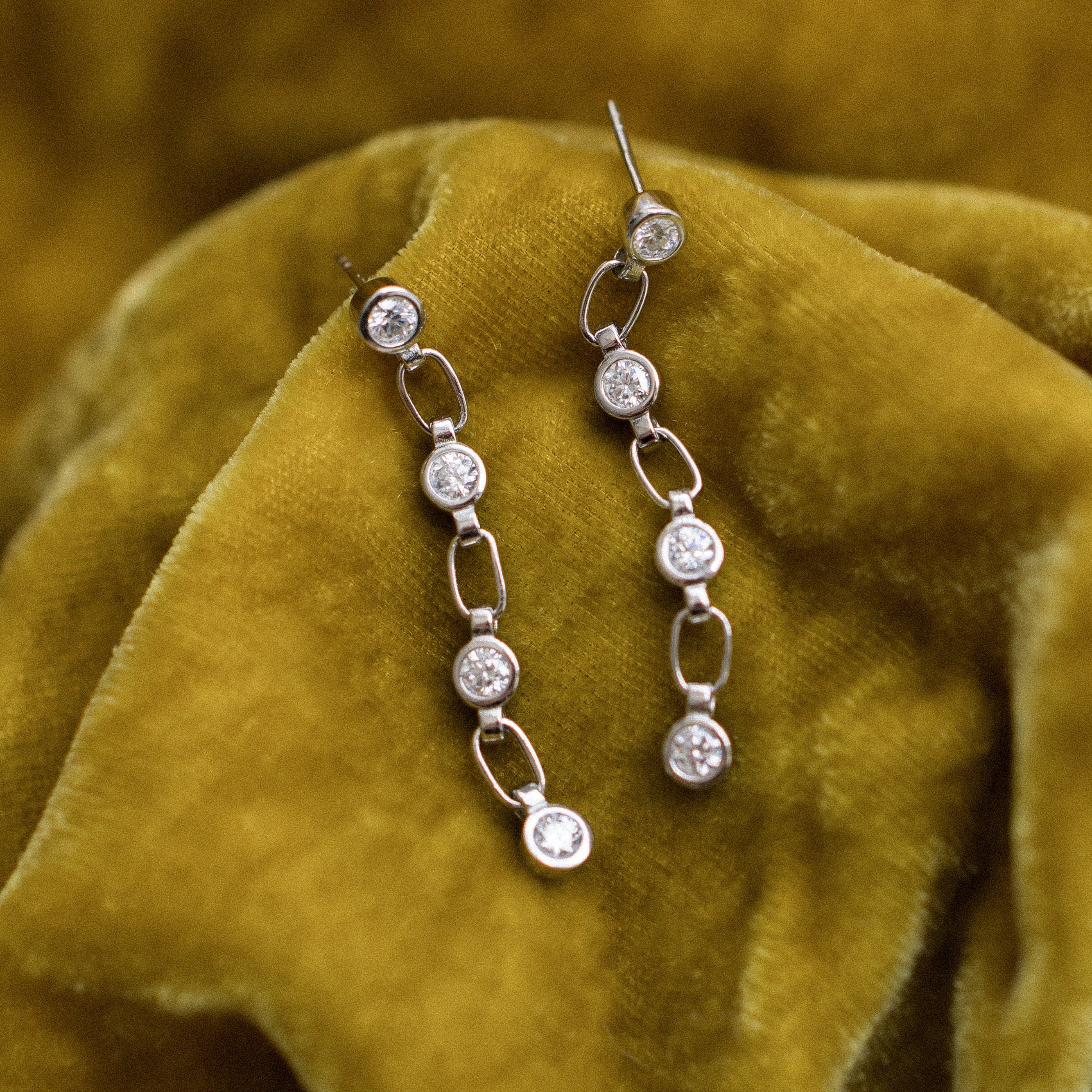 White gold vermeil post earings with paperclip chain and bezel set moissanites. Perfect demi-fine gift or everyday wear. Sold by Cival in Milwaukees Bayview.