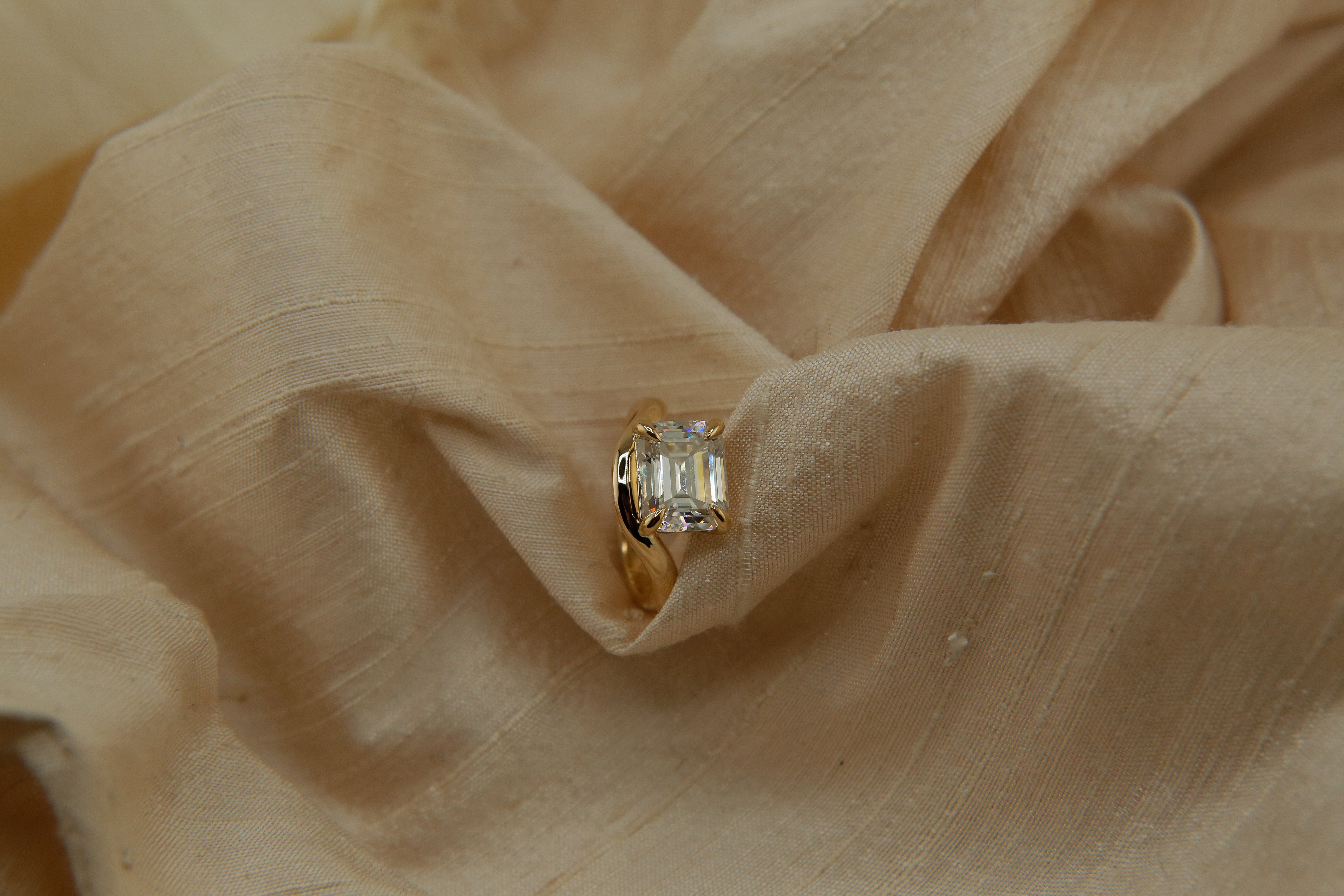 Hydra ring with a soft curved band, an emerald cut moissanite. Perfect for an engagement