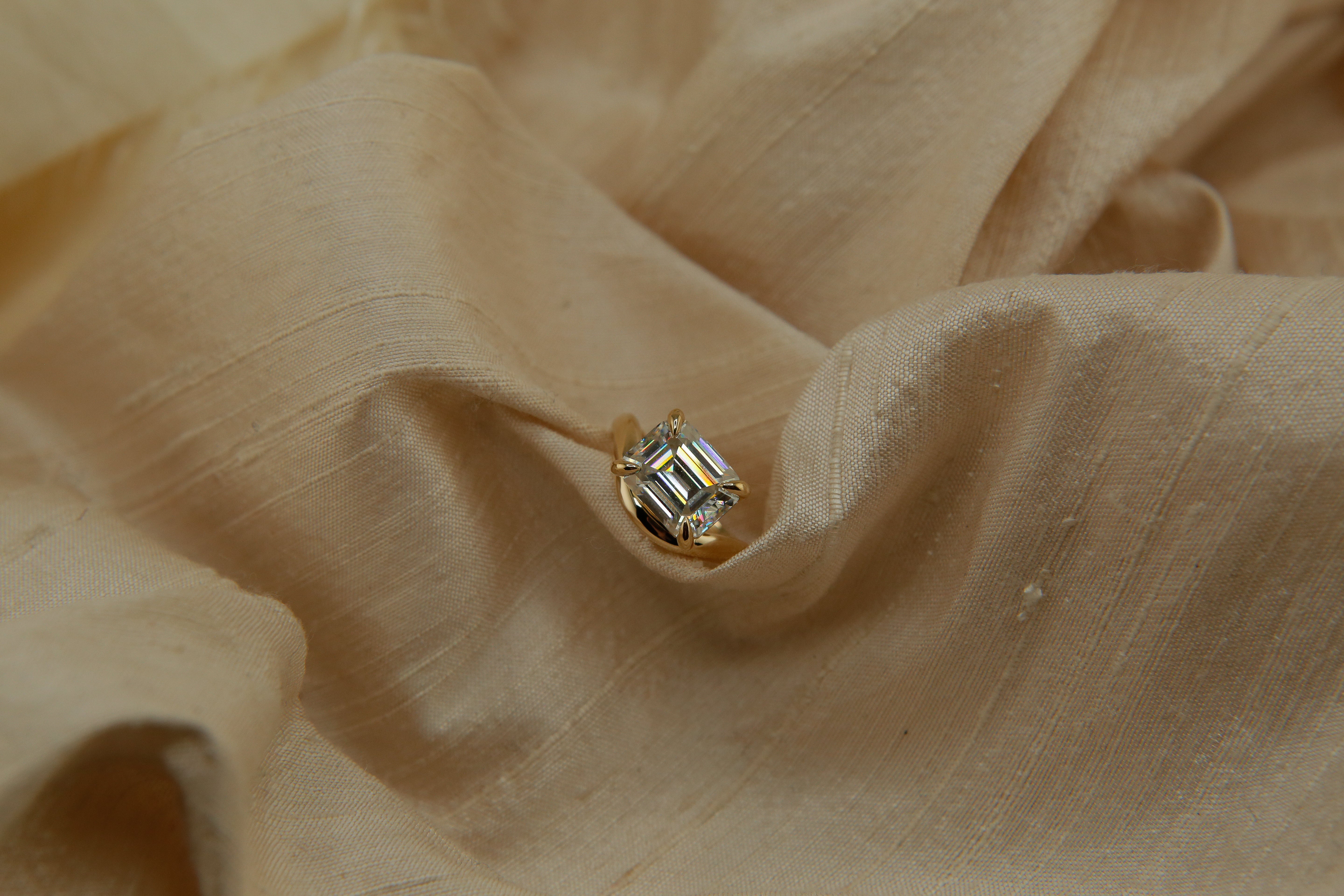 Hydra ring with a soft curved band, an emerald cut moissanite. Perfect for an engagement