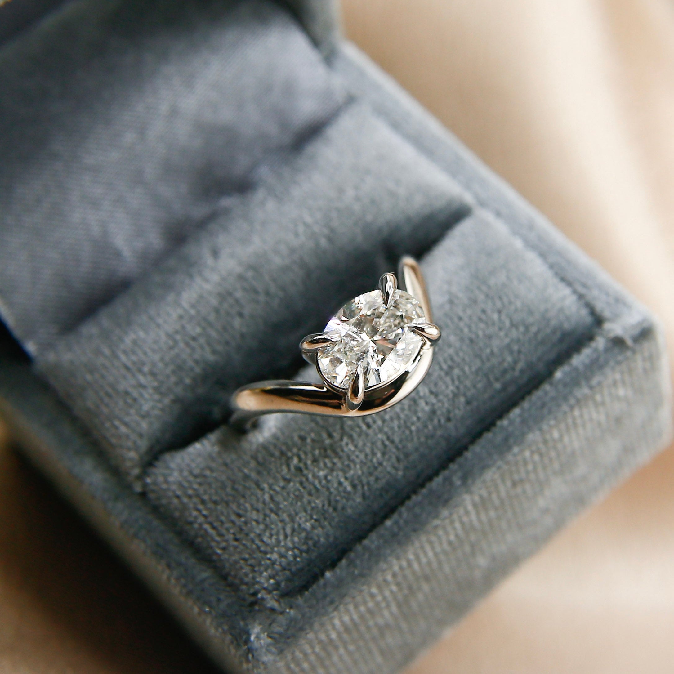14k white gold oval east west diamond wave engagement ring with claw prongs. Customize this unique ring with your choice of stone type, stone shape and stone size. Diamond, moissanite, round, oval, princess, cushion, asscher, marquise. Cival in Milwaukee Wisconsin.