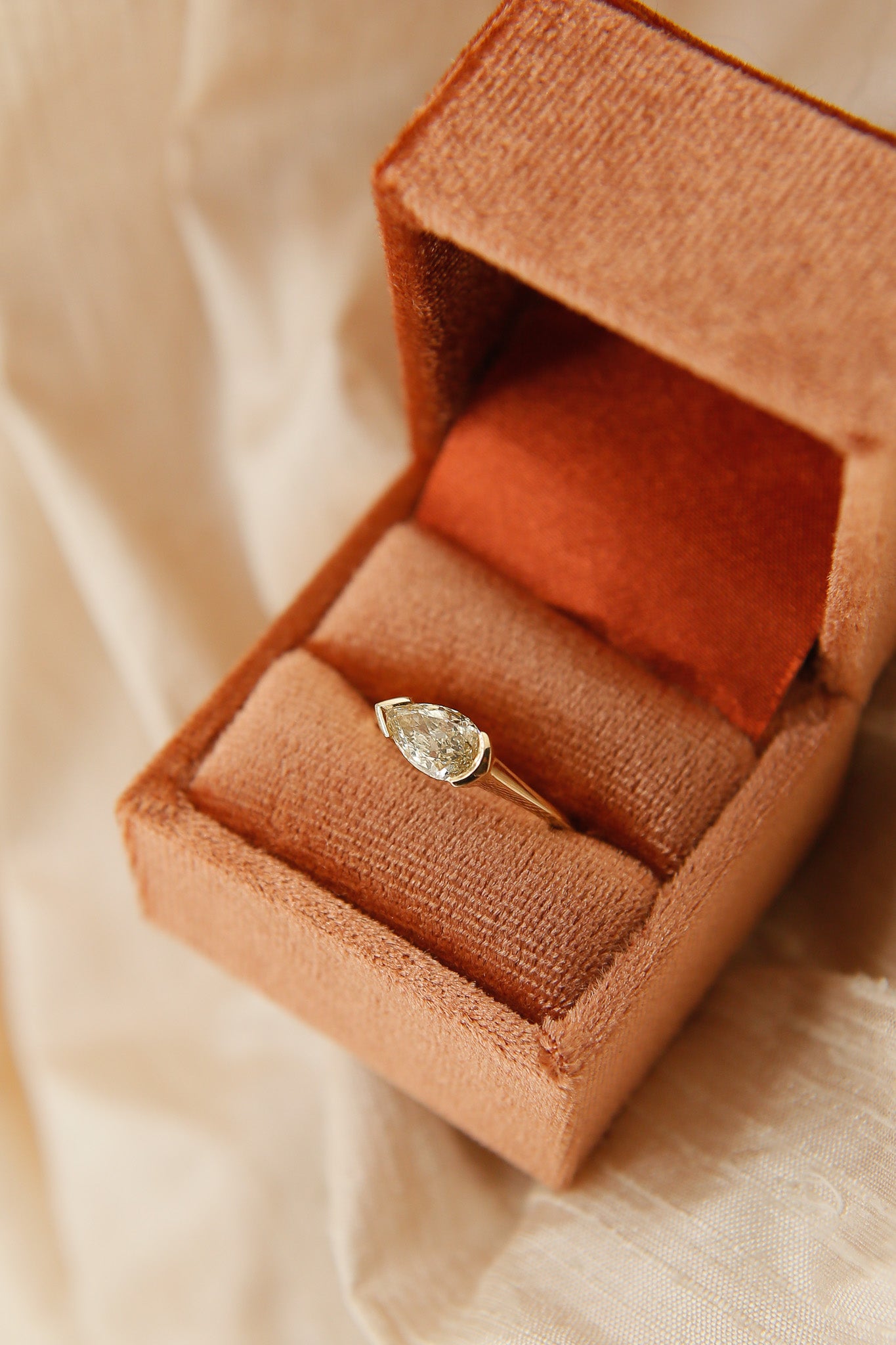 Teardrop-shaped diamond ring in a velvet box