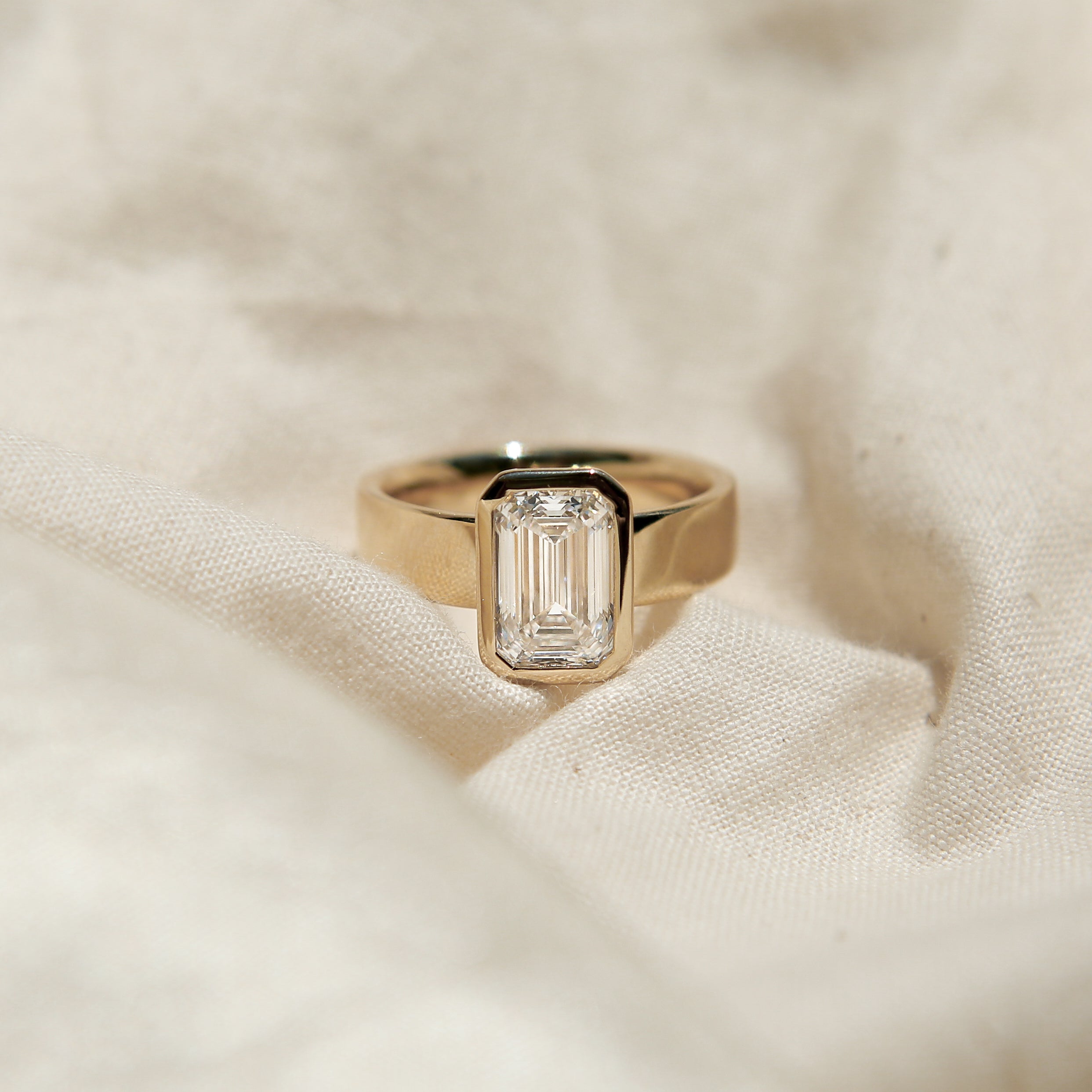 Wide band engagement ring in 14k with a bezel set stone. Customize this unique ring with your choice of stone type, stone shape and stone size. Diamond, moissanite, round, oval, princess, cushion, asscher, marquise. Cival in Milwaukee Wisconsin.