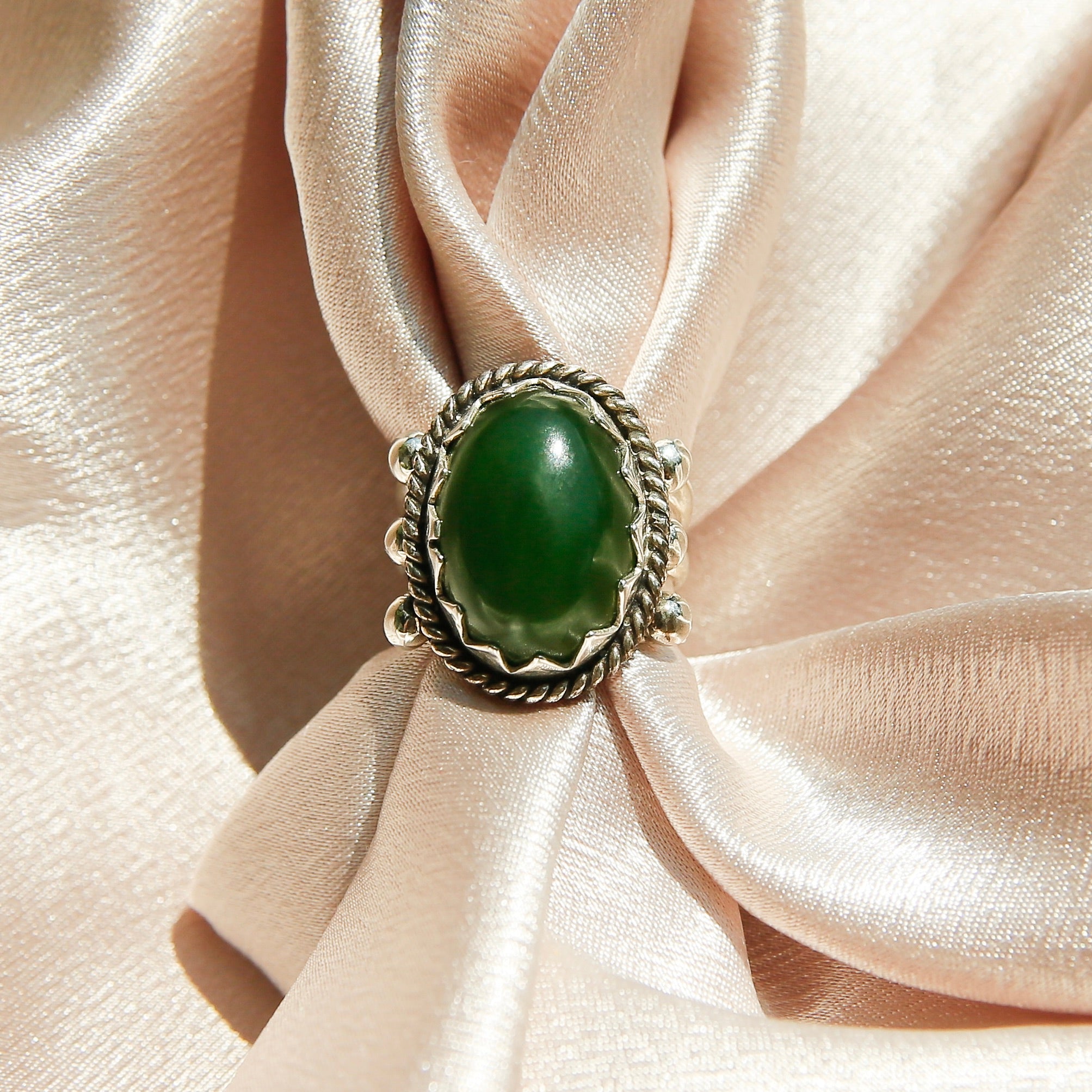 Sterling silver 3 band ring with a green oval stone. This ring has a bezel like setting made of sharp edges and a rope frame that has been patinated. Sold by Cival Collective in Milwaukee Wisconsin.