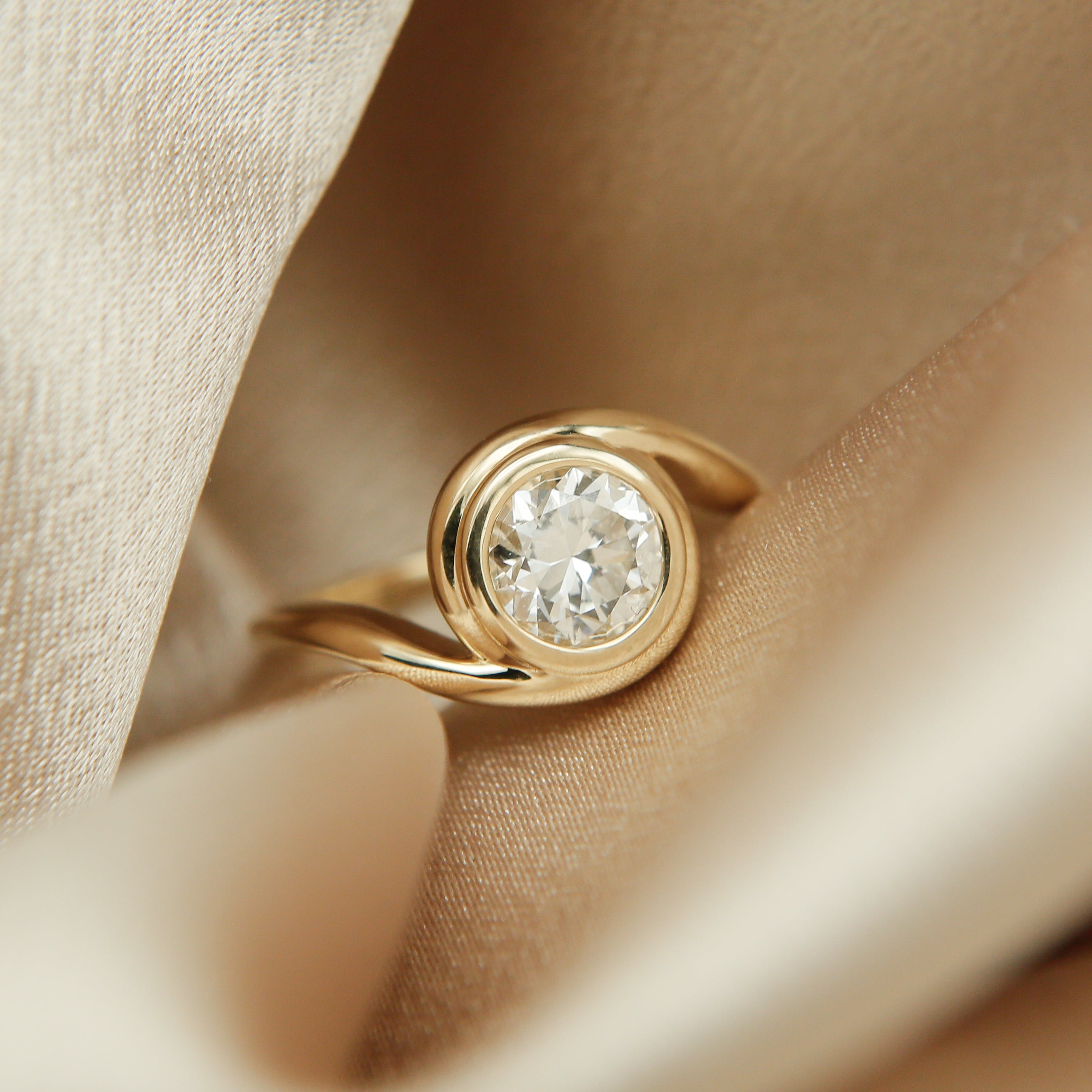 14k gold engagement ring in a bypass style. Full bezel for the stone setting. Customize this unique ring with your choice of stone type, stone shape and stone size. Diamond, moissanite, round, oval, princess, cushion, asscher, marquise. Cival in Milwaukee Wisconsin.