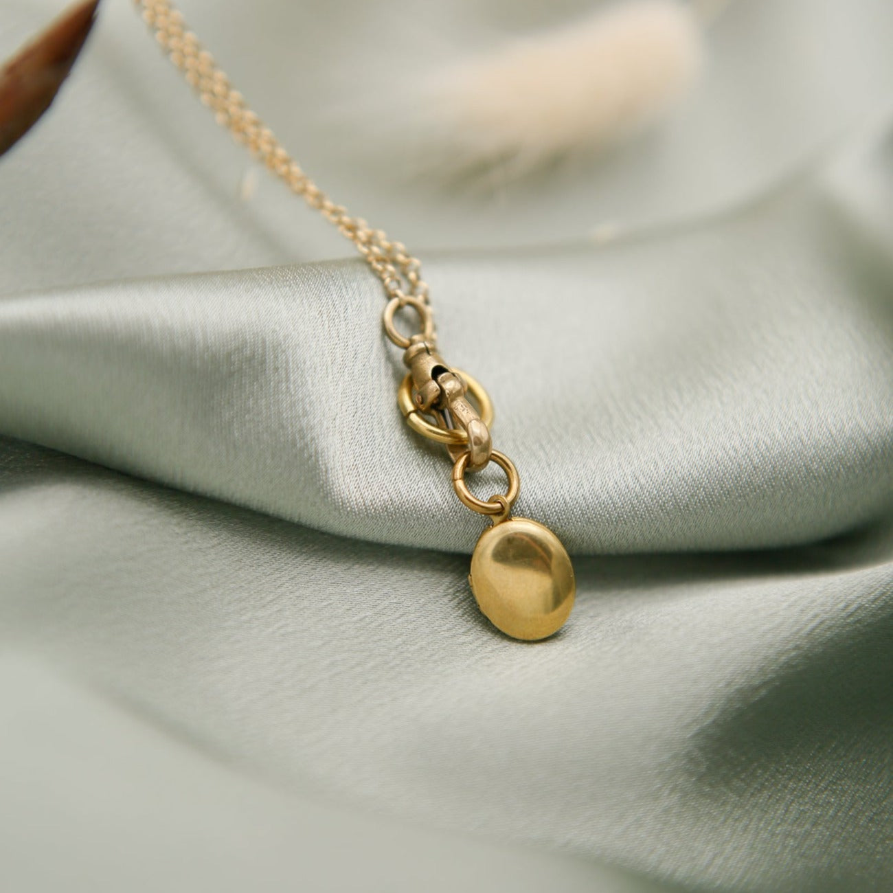 Tiny oval brass locket on a gold fill chain with a brass swivel clasp locket
