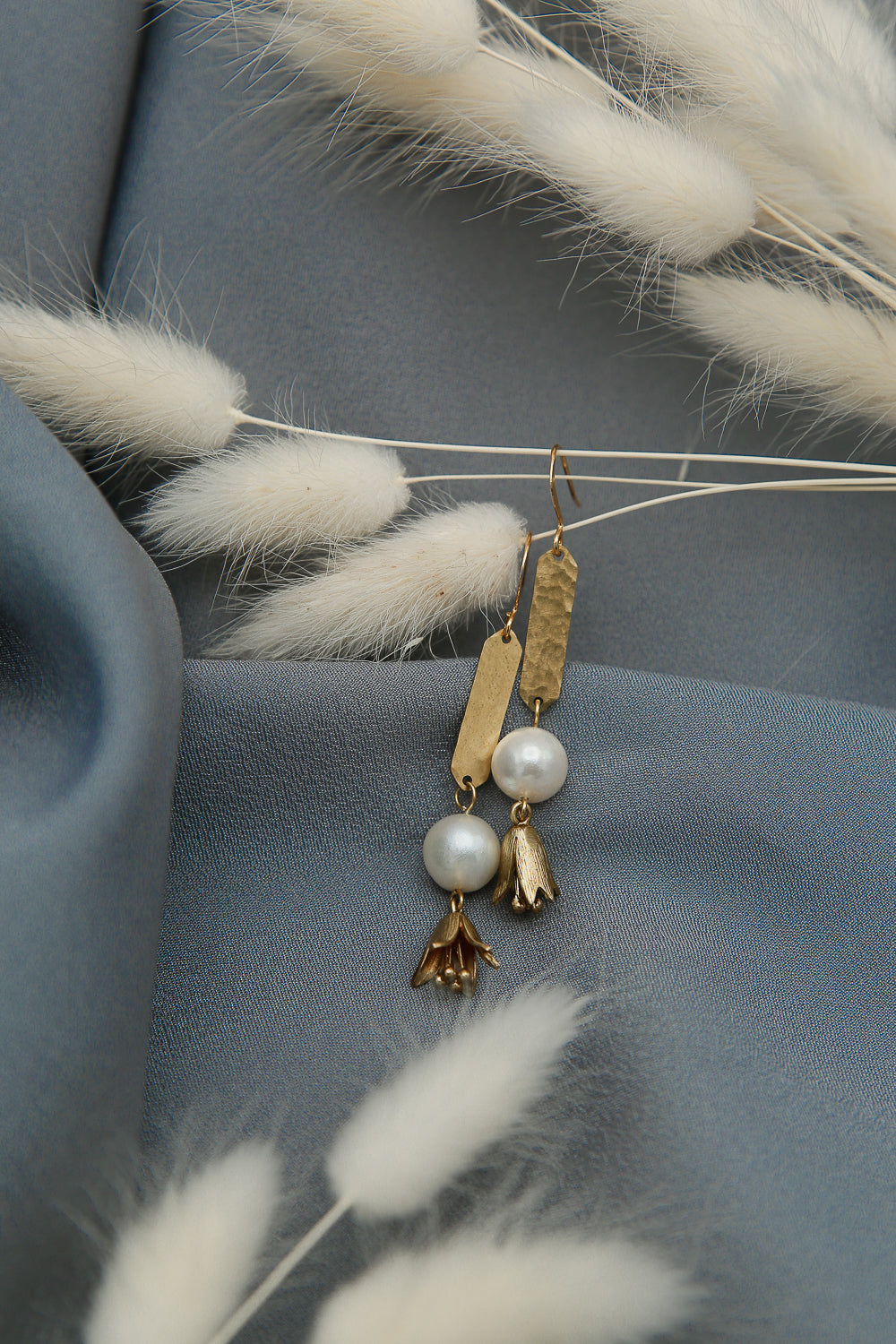 Pearl earrings with textured brass and flower drops