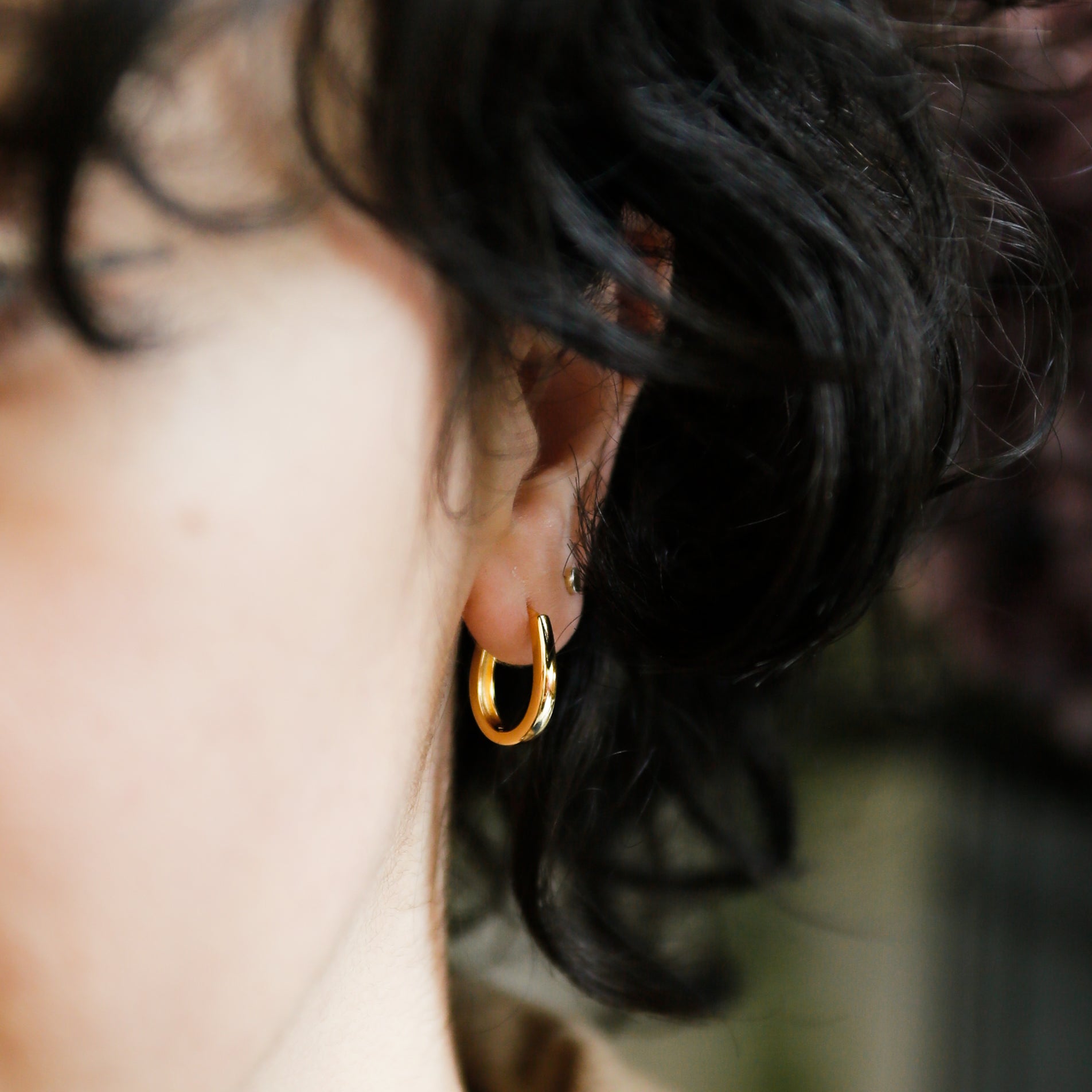 close up of model wearing gold sunna hoops