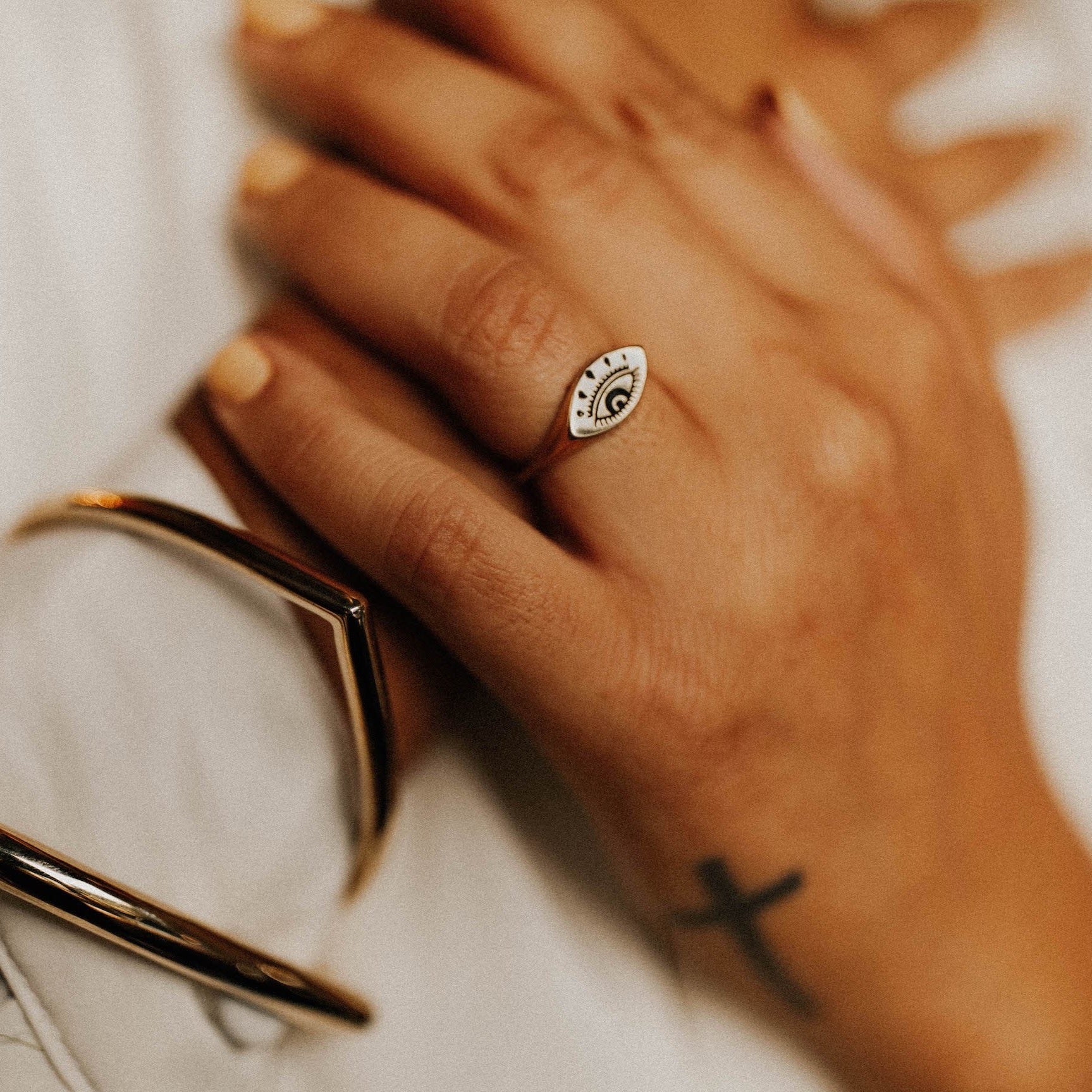 Model wearing lera evil eye ring cast in brass, designed my Cival Collective in Milwaukee Wisconsin