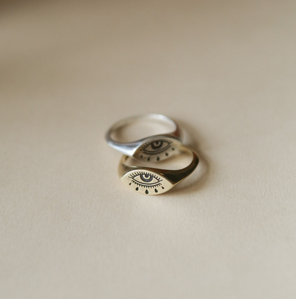 Brass and sterling silver evil eye rings stacked on one another