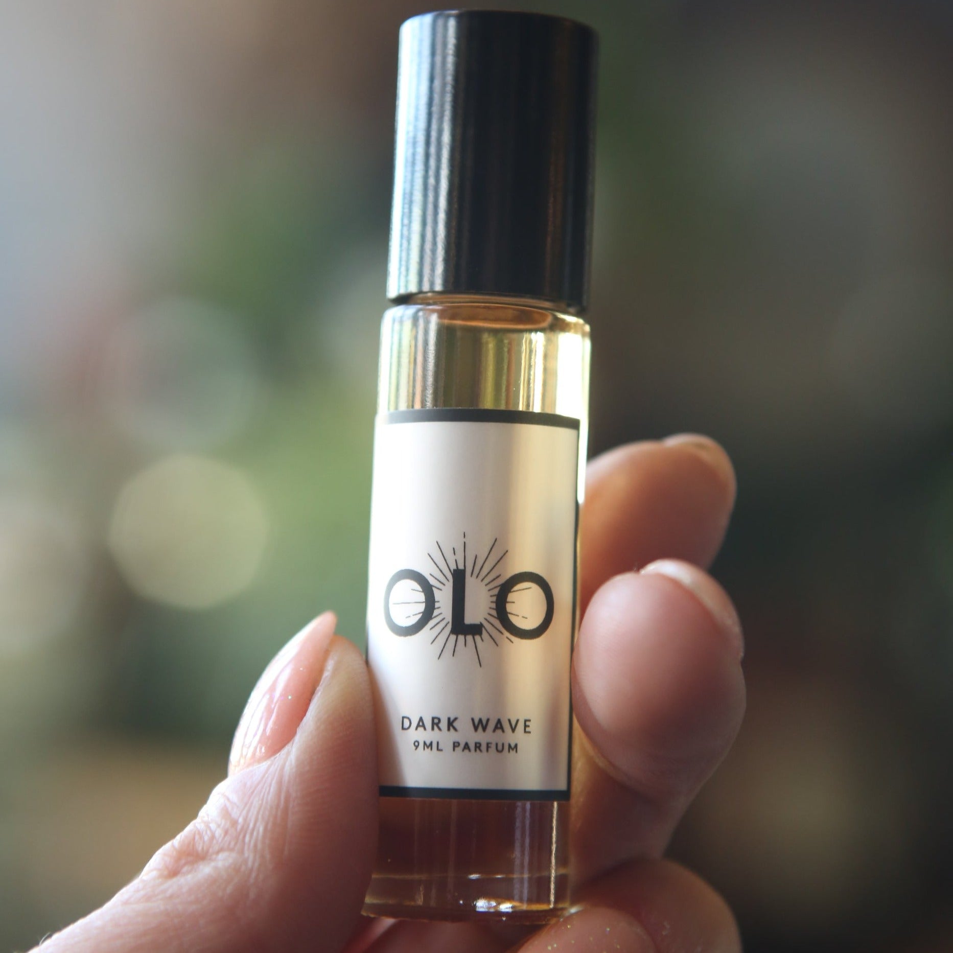 roll on perfume glass bottle with black plastic top. labeled "olo dark wave"