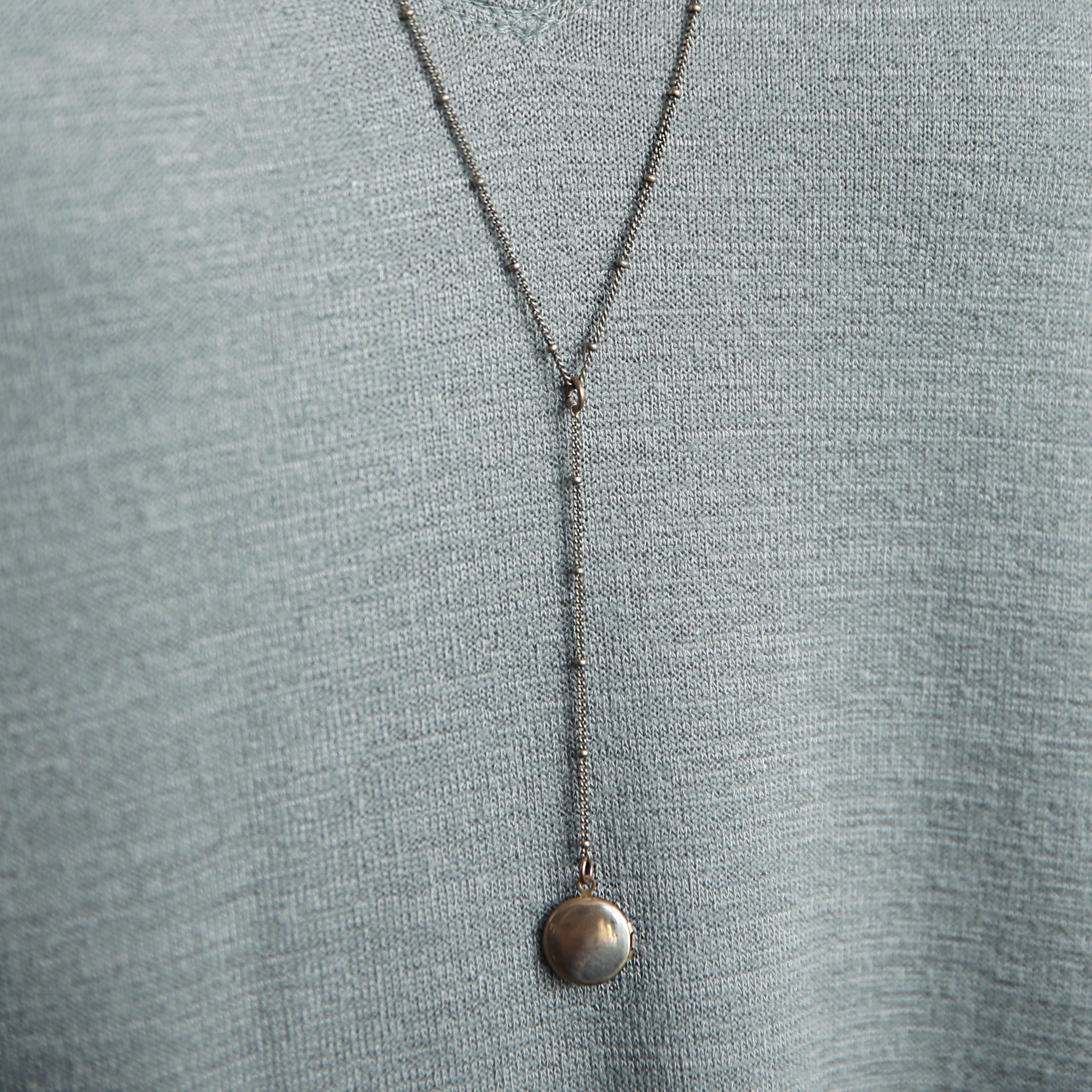 Rosary style "Vie" necklace on satellite chain with a 2 inch drop and small brass locket at the end.