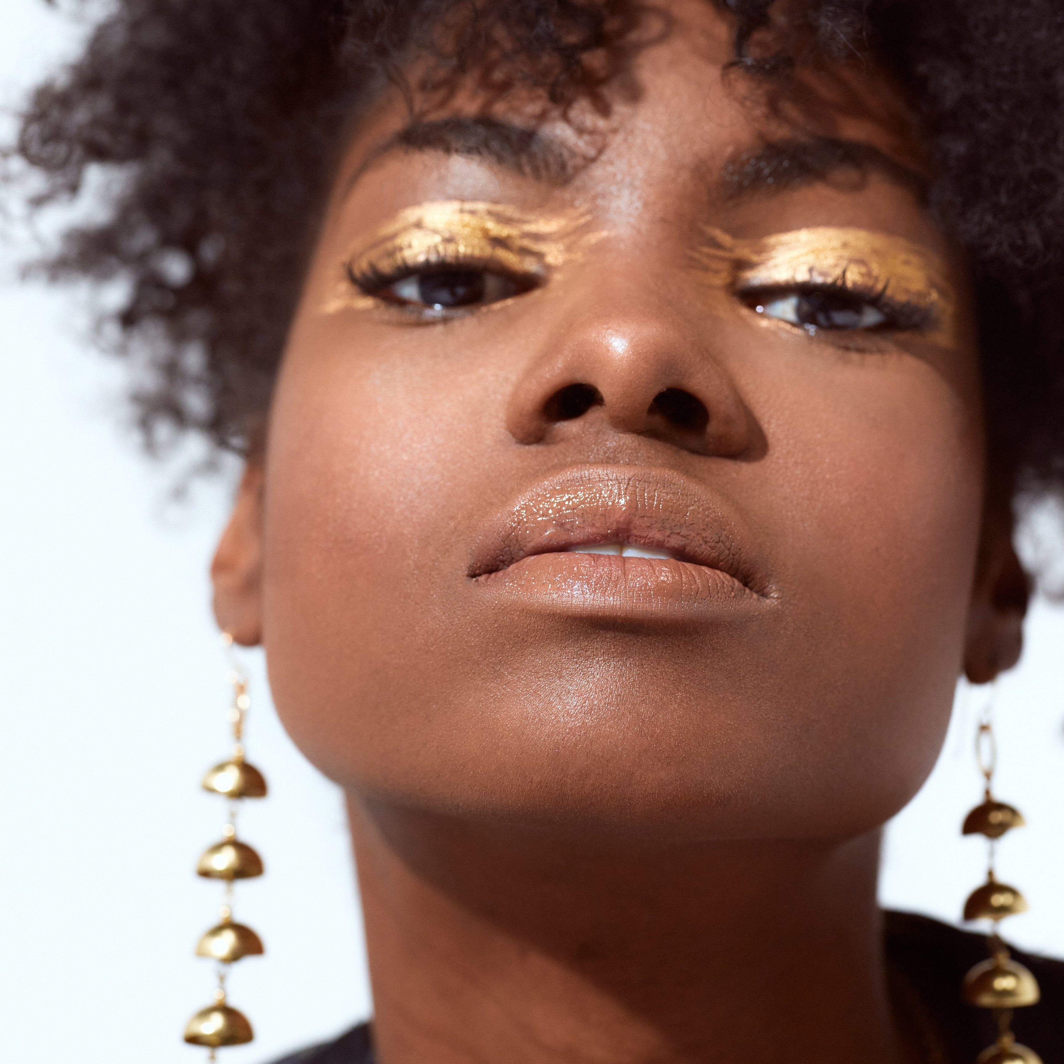 Daphne brass bell drop earrings on model