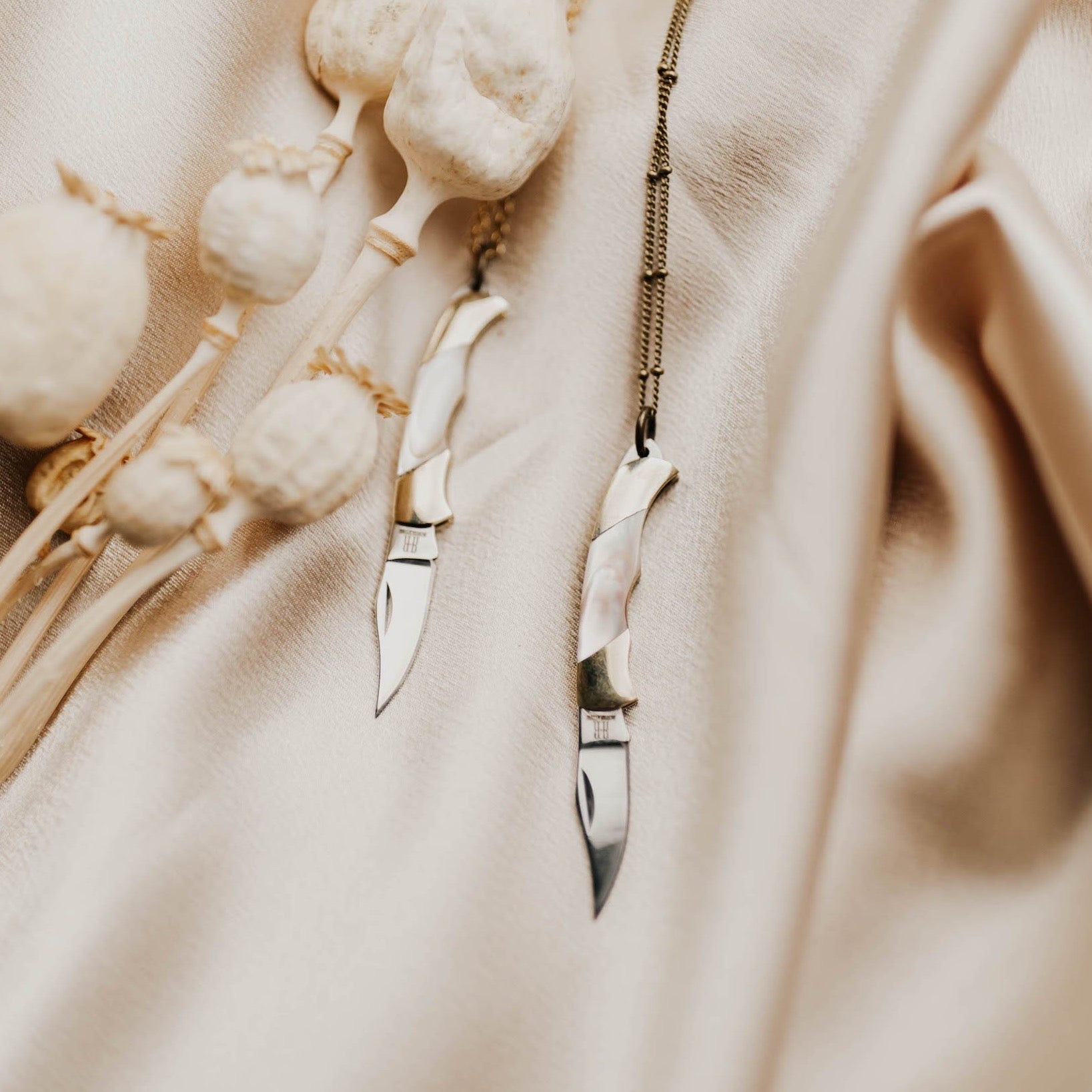 two pocket knife pendants on brass satellite chain