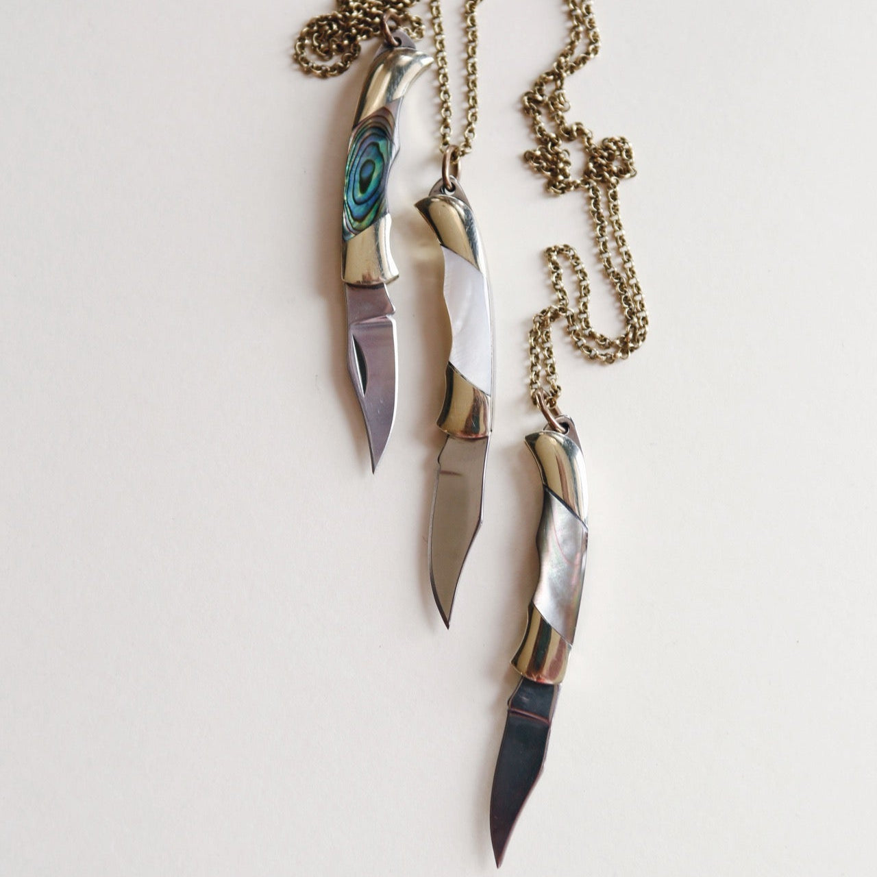 Three pocket knife necklaces with chains intertwined organically made in the USA Milwaukee WI