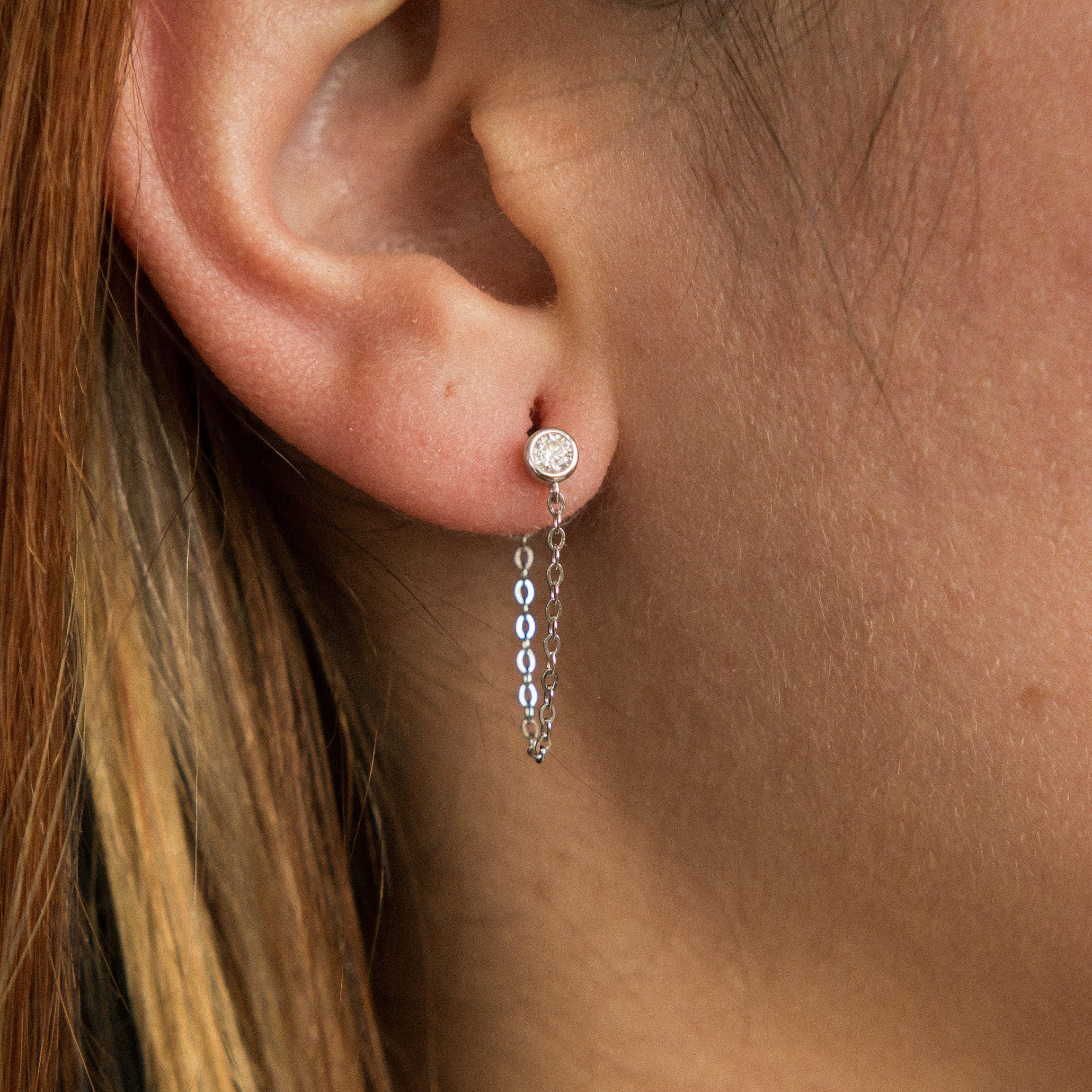 White gold filled moissanite studs with a chain that connects from front to back. Sold by cival in bayview Milwaukee wisconsin