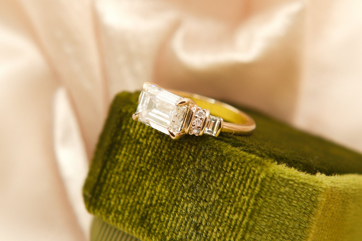 Diamond ring on a green fabric with a soft pink background