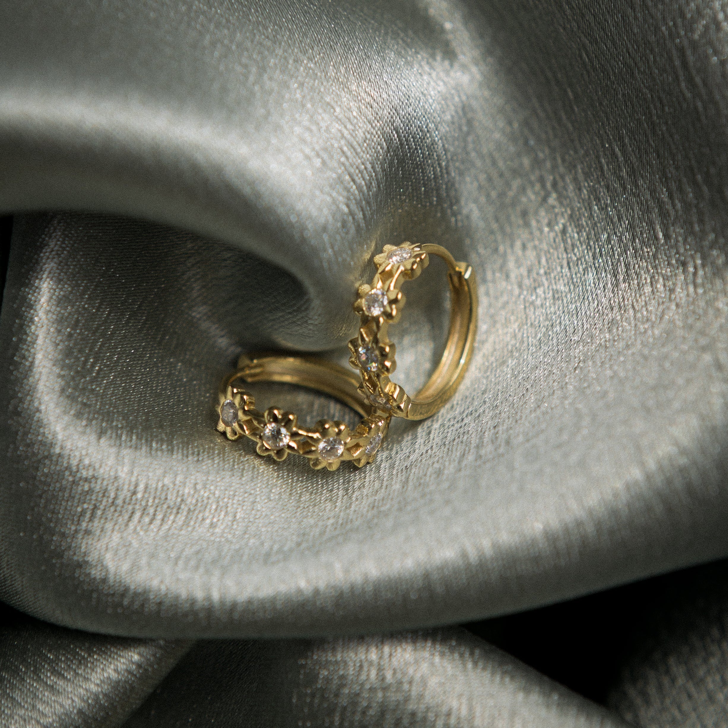 Yellow gold vermeil hoops with floral detailing and moissanite centers. Perfect demi fine gift or everyday wear. Sold by Cival in milwaukees bayview