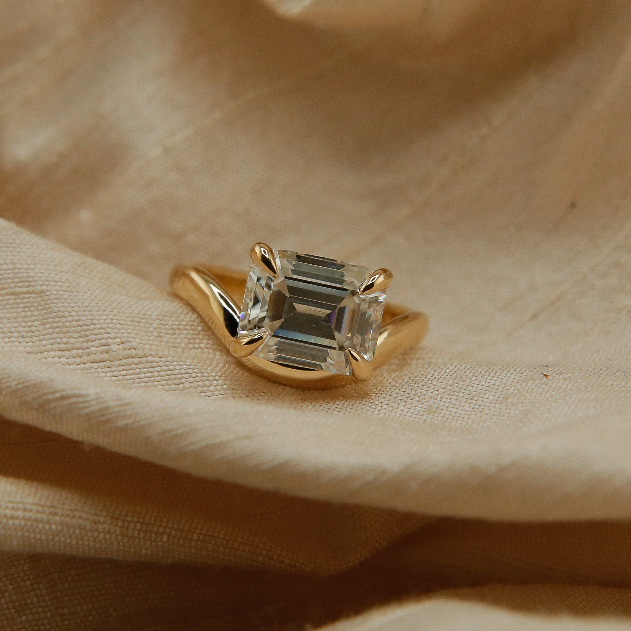 Hydra ring with a soft curved band, an emerald cut moissanite. Perfect for an engagement