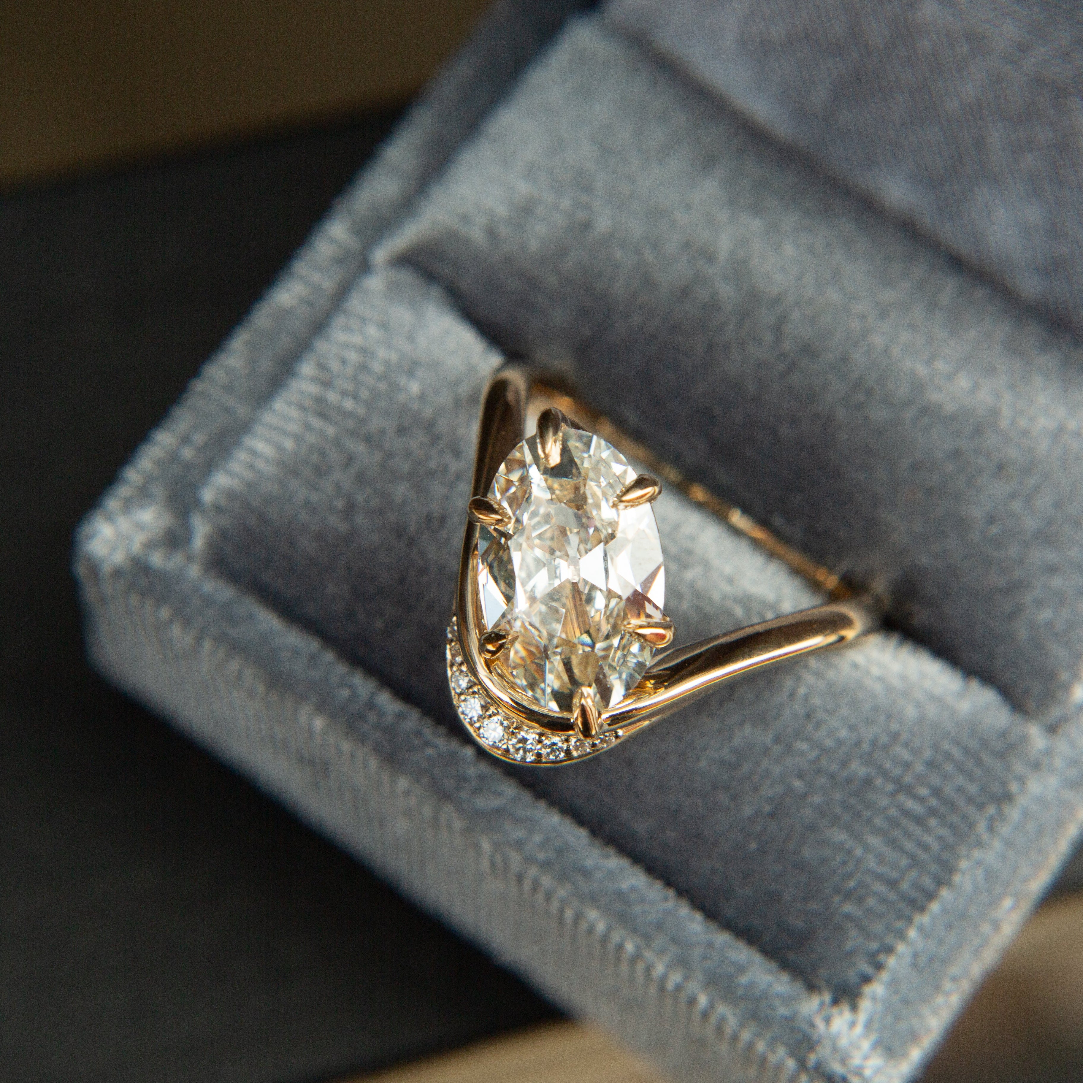 gold wave ring with an antique cut oval diamond