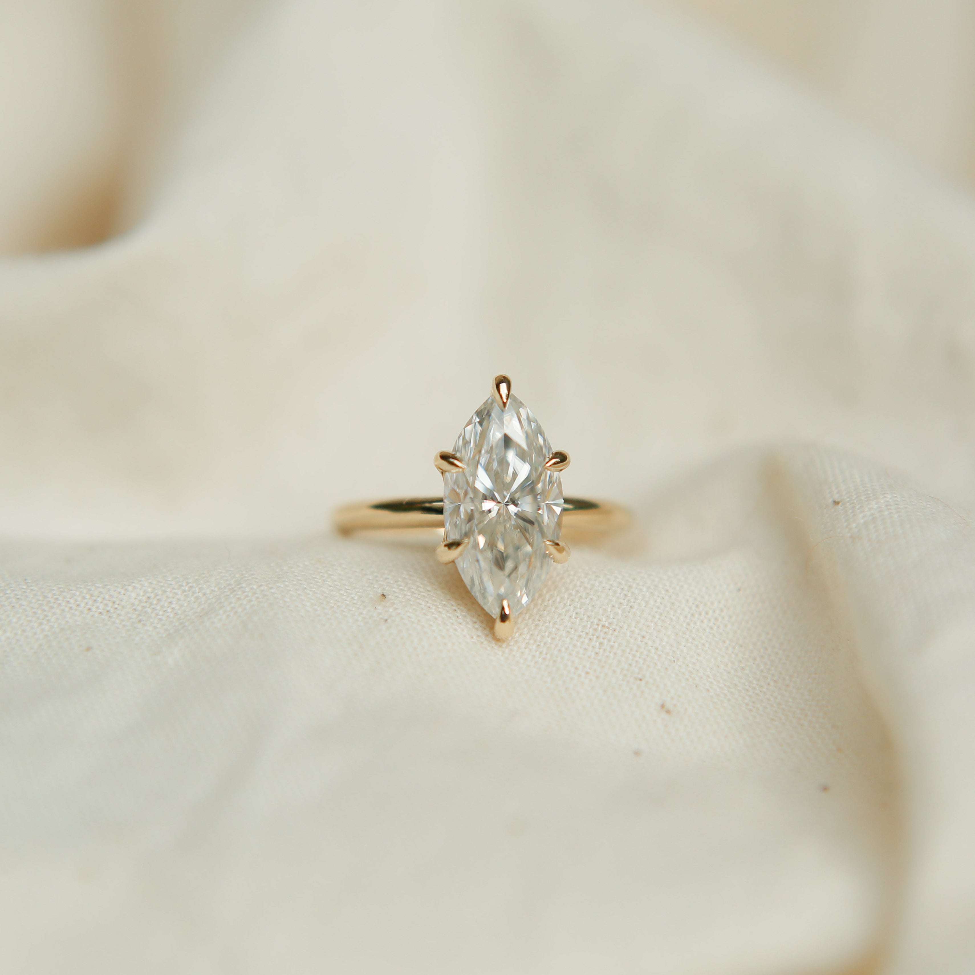 Diamond ring on a soft beige fabric background