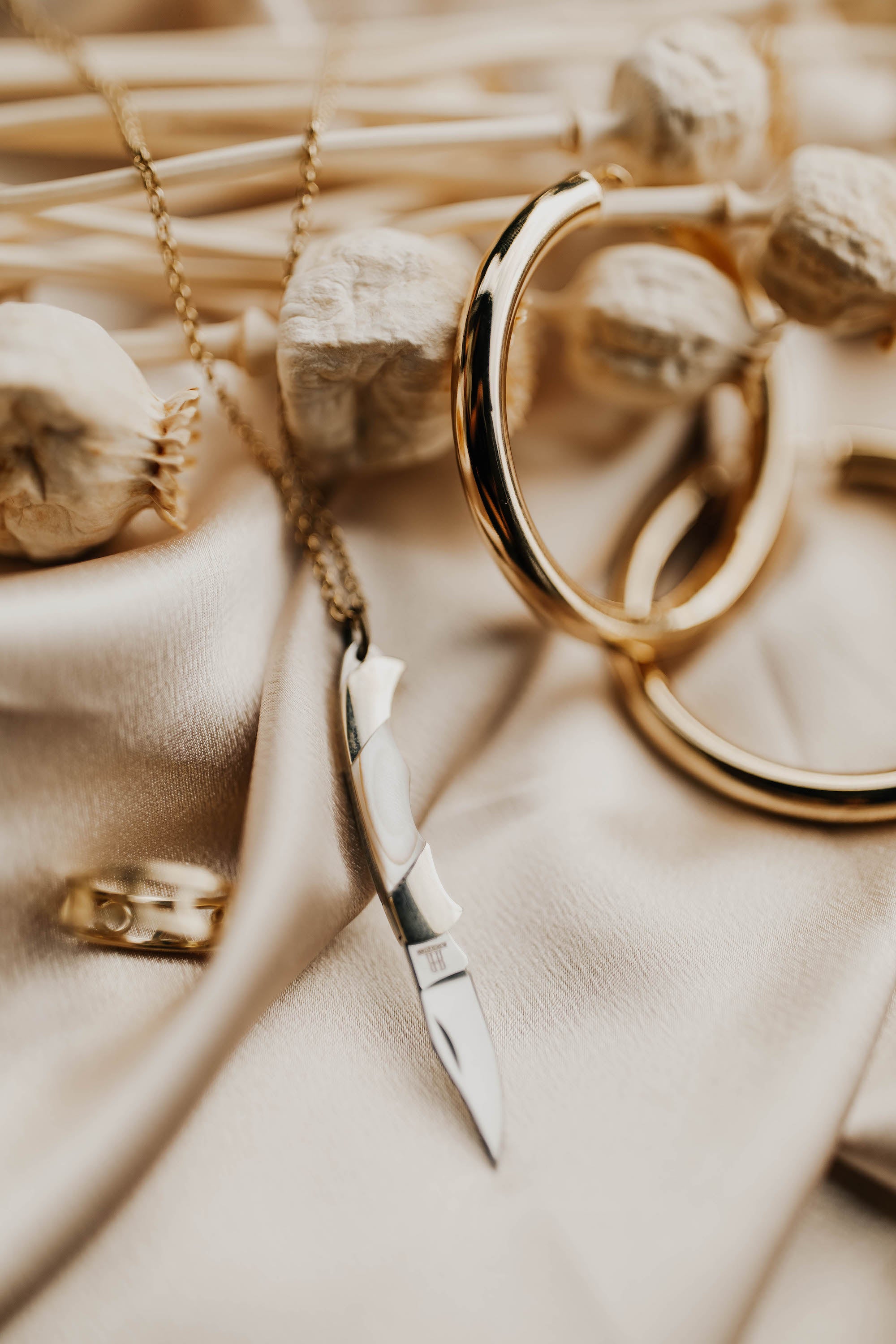 brass pocket knife with blade open, on gold chain